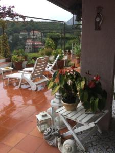 a patio with two chairs and a table and potted plants at B&B Le Tre Casette in Maratea