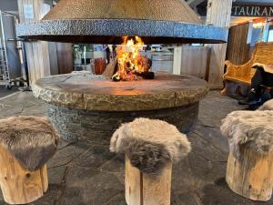 a stone fire pit in a shopping mall with a fire at Hotel Port 1730 in La Coma i la Pedra