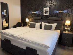a bedroom with a large bed with white sheets and pillows at Pension Burkhardt in Meißen