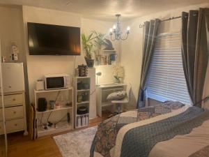 a bedroom with a bed and a tv on the wall at Fenland Gallery in Whittlesey