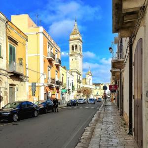 a city street with a clock tower in the distance at LA SEGRETA DEL CASTELLO, Private Access in Gioia del Colle