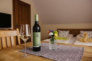 a bottle of wine and a glass on a table at Gästezimmer & Weingut Gamser in Leutschach