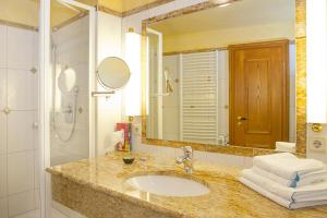 a bathroom with a sink and a mirror at Hotel Wilder Mann in Königstein in der Oberpfalz +28 photos