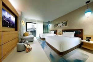 a hotel room with two beds and a couch at Hard Rock Hotel Malta in St. Julianʼs