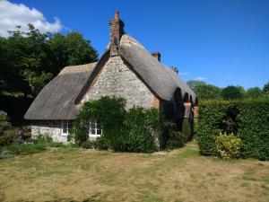 an old stone cottage with a thatched roof at The Cottage in Fyfield