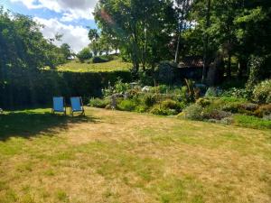 two blue chairs sitting in the grass in a garden at The Cottage in Fyfield +28 photos