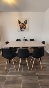 a dining room table with chairs and a painting at Parenthèse 8 pers-6 mns Futuroscope-Famille in Chasseneuil-du-Poitou