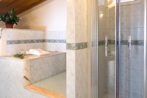 una doccia con una porta in vetro in un bagno di B&B L'Approdo a Piano di Sorrento