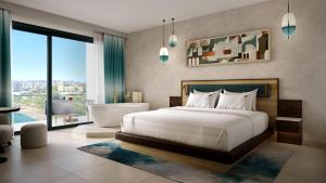 a bedroom with a bed and a bath tub and a bathroom at Hard Rock Hotel Malta in St. Julianʼs