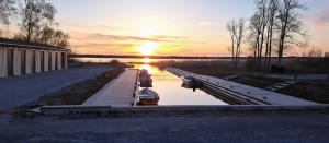 a dock with two boats on the water at sunset at Suurlahe Guesthouse in Kuressaare