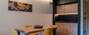 a dining room with a wooden table and yellow chairs at Chambre d'Hotes Vista Monte Bianco in La Salle