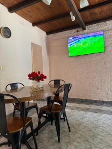 a table and chairs with a television on a wall at Patagonia Faro Norte Lighthouse in Carmen de Patagones