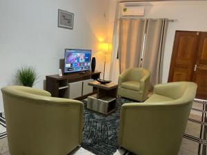 a living room with two chairs and a television at TOU R serjo polo in Douala