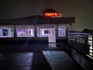 a toll booth with a neon sign at night at TOU R serjo polo in Douala