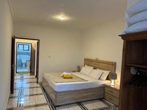 a bedroom with a large bed with a wooden headboard at TOU R serjo polo in Douala