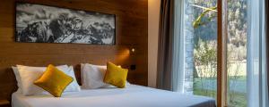 a bedroom with a bed with yellow pillows and a window at Chambre d'Hotes Vista Monte Bianco in La Salle