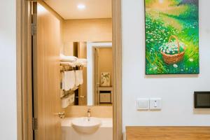 a bathroom with a sink and a painting on the wall at Luxury 1BR Apartment - Ocean Lake View - Vinhomes Ocean Park in Gia Lâm Pho