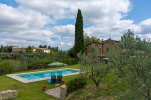a pool in front of a house with a tree at Villa Sunset in Greve in Chianti