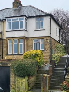 a brick house with stairs in front of it at Bank End Cottage in Almondbury
