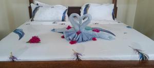 a bed with two swans made out of towels at Zamani Matemwe House in Matemwe