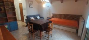 a small room with a bed and a table and chairs at Casa Vacanze Da Ile 2 in Malborghetto Valbruna +1 photo