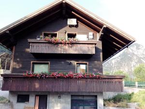 a house with a balcony with flowers on it at Casa Vacanze Da Ile 2 in Malborghetto Valbruna
