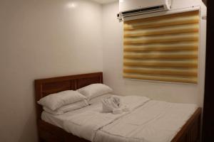 a bedroom with a bed with white sheets and pillows at Homestay in Lipa City in Lipa
