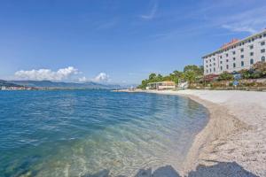 a beach next to a building and the water at Central Beach Retreat in Trogir