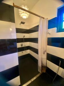 a bathroom with a shower with black and white stripes at Casa Monkey 28 in Bentota