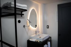 a white bathroom with a sink and a mirror at Priede Hotel Boutique in Puebla
