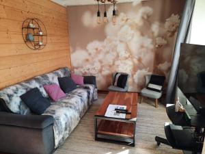 a living room with a couch and a tv at Ecrin de Valdeblore in Valdeblore