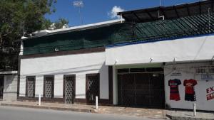 a white building with a door with a soda advertisement on it at Comfortable apartment in downtown Reynosa in Reynosa