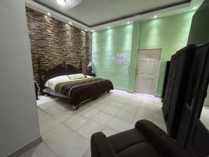 a bedroom with a bed and a brick wall at Comfortable apartment in downtown Reynosa in Reynosa