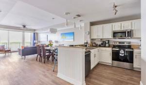 a kitchen with white cabinets and a dining room and a table at Blue Heron Resort in Orlando