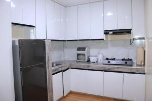 a kitchen with white cabinets and a stainless steel refrigerator at Homestay in Lipa City in Lipa +14 photos