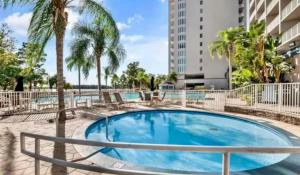 a swimming pool with palm trees and a building at Blue Heron Resort in Orlando