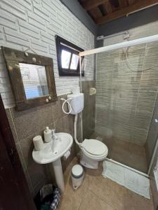a bathroom with a toilet and a sink and a shower at Pousada Vale da Praia in Praia do Rosa