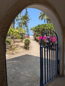an archway leading to a garden with pink flowers at Crystal Apartments in Malindi +47 photos