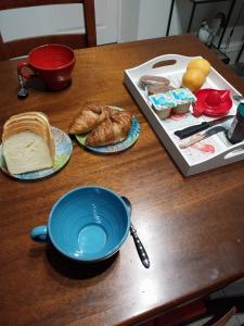 a table with a blue bowl and bread and croissants at Les aires in Tourbes