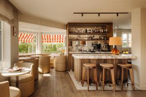 a restaurant with a bar with stools and tables at Hotel Villa Bonnie in Knokke-Heist