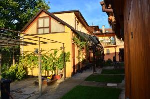 a yellow house with a courtyard with plants at ubytování MILUMI in Strážnice