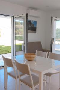 a white table with white chairs and a bowl on it at Casa da Pegada in Macedo de Cavaleiros