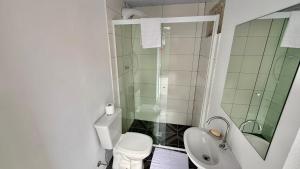 a bathroom with a shower and a toilet and a sink at Chalé 01 centro de itapema 150m do mar in Itapema +8 photos