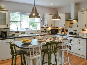 a kitchen with a table with a bowl of fruit on it at Quarryman's Cottage in Belford +16 photos