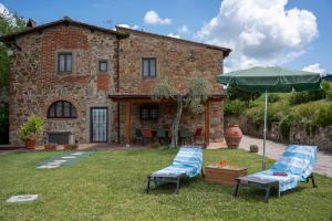 two chairs and an umbrella in front of a house at Villa Sunset in Greve in Chianti +49 photos