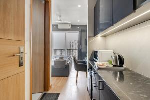 a kitchen with a counter top and a room at Kaveri Studio Apartment near India Expo Centre in Greater Noida