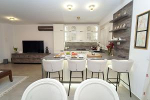 a kitchen with a table and white chairs in a room at KLM holiday home in Rupalj