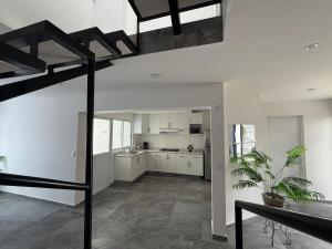 a large white kitchen with a staircase in a house at Casa Alejandra, Bernal Pueblo Magico in Bernal +33 photos