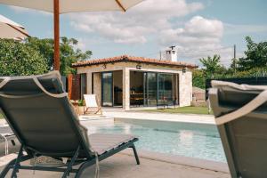a chair and an umbrella next to a swimming pool at KLM holiday home in Rupalj