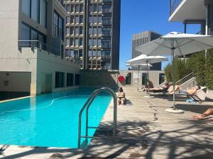 a swimming pool with people lounging in a building at 312 Mutual Heights Building in Cape Town